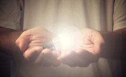 Open hands with light bulb